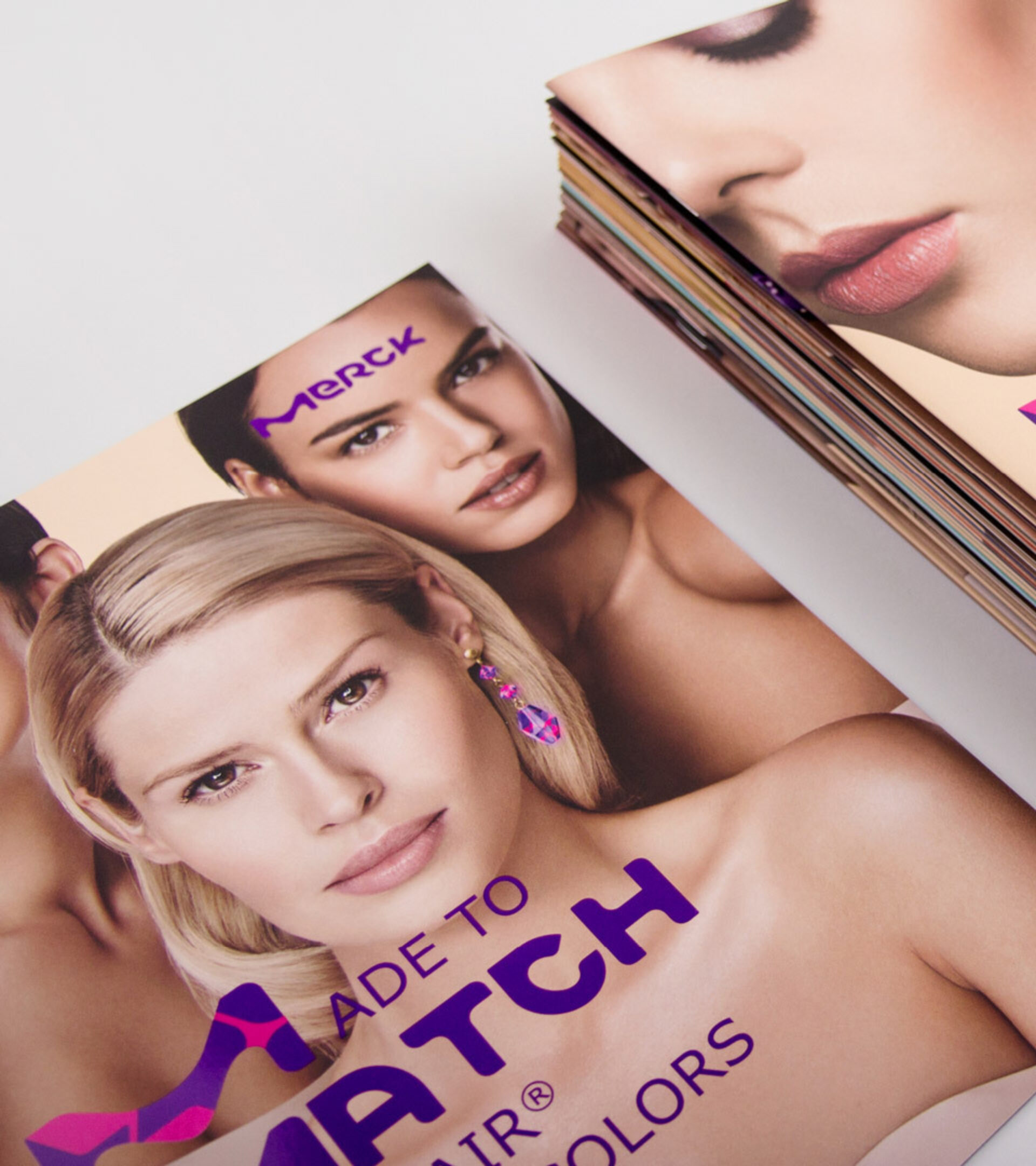 Gestapelte Kosemetikbroschüren mit mehren Frauen und der violetten Headline „Made to Match“
